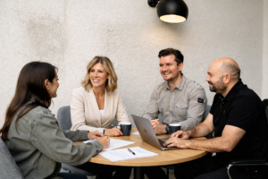 Clients meeting with a financial adviser around a table, discussing next steps in their financial planning journey.